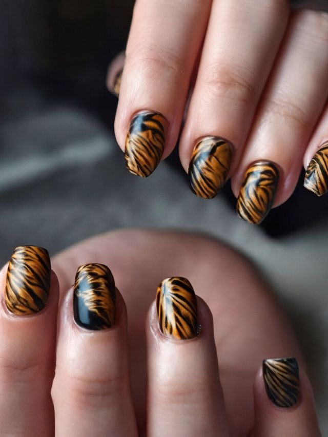 A woman's nails with tiger print designs.