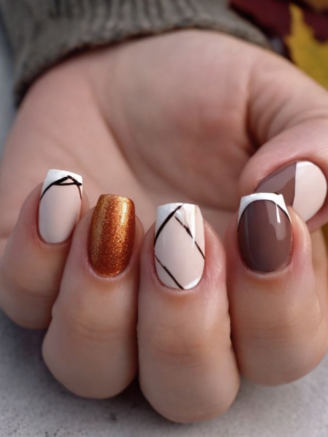 A woman's hand holding a white, brown, and beige manicure.