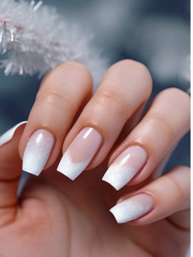 A woman's hand with white nails and snowflakes on it.