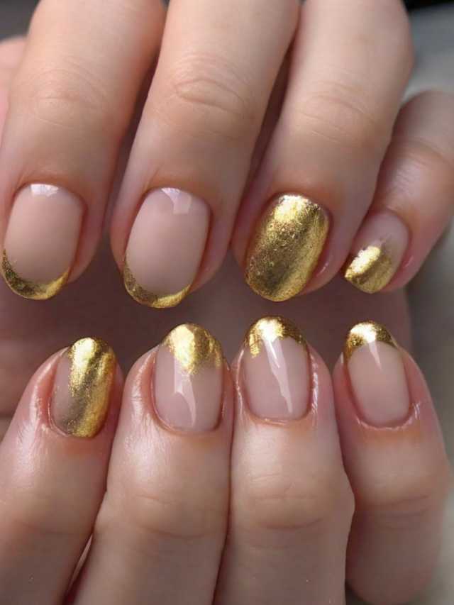 A woman's hands with gold nail polish on them.