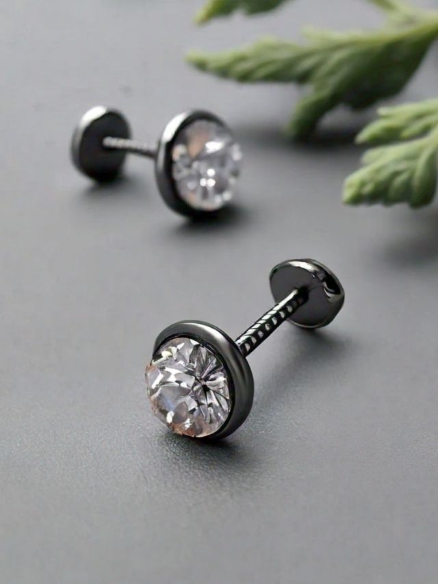 A pair of black cz stud earrings on a table.