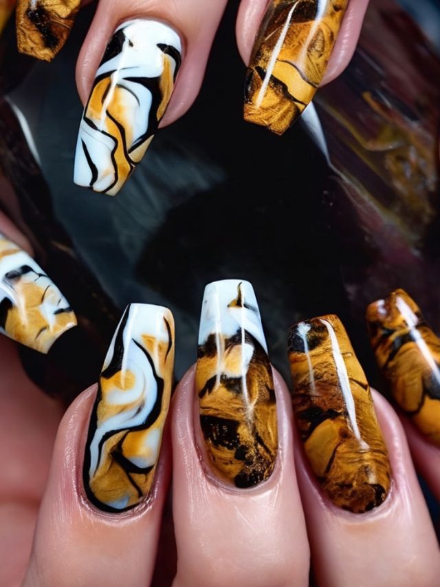 A woman's nails with marble designs on them.