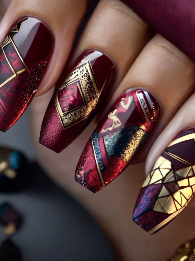 A woman's nails are decorated with gold and red designs.
