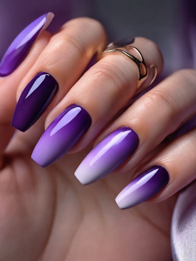 A woman's hand with purple and white ombre nails.