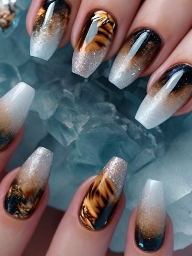 A woman's nails with tiger designs on them.