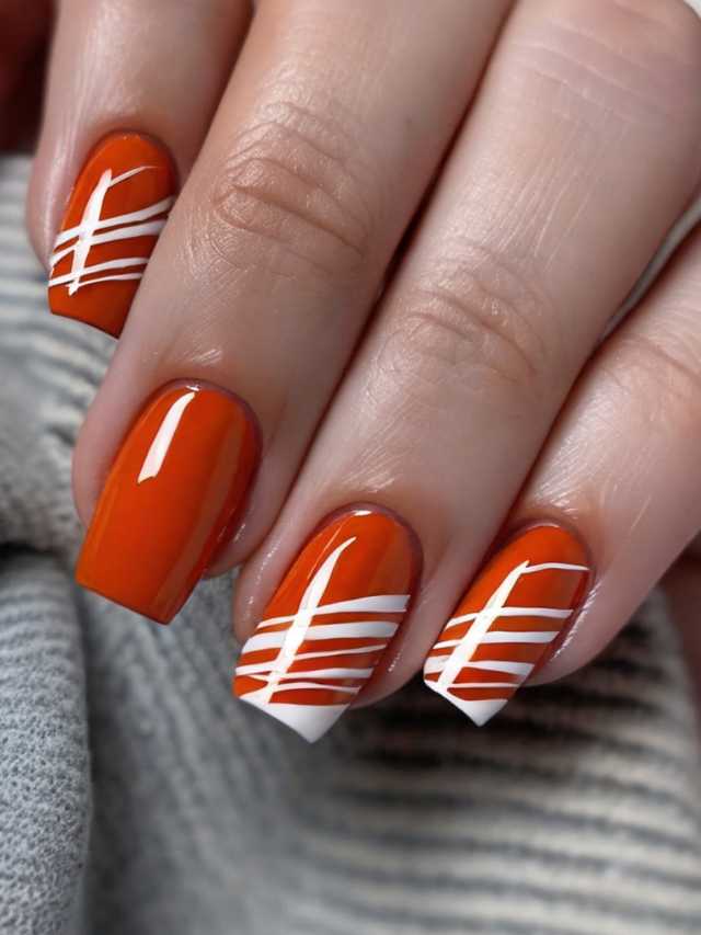 A woman with orange and white stripes on her nails.