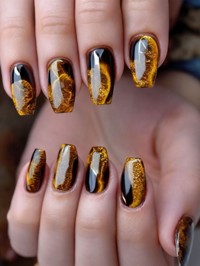 A woman's nails with yellow and black marble designs.