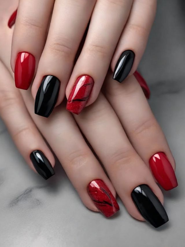 A woman's hands with striking red almond nail designs.