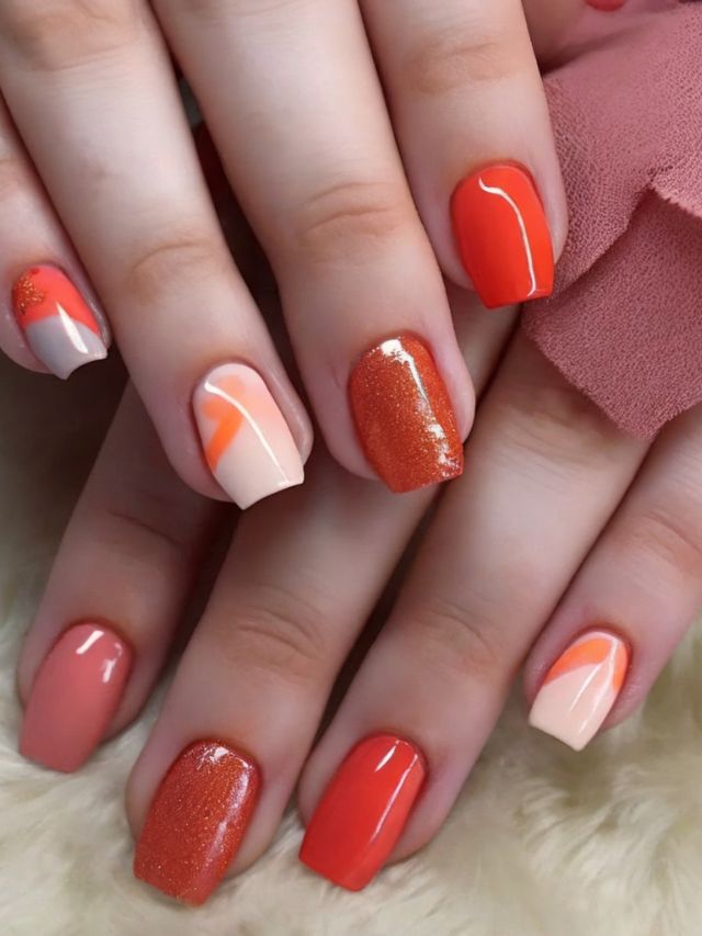 A woman's hand with orange and white nails.