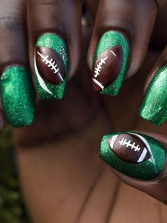 A Superbowl-inspired nail design featuring a green nail with a football on it.