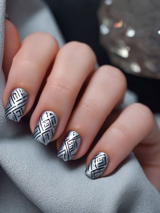 A woman's hand with a silver geometric design on her nails.