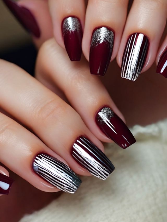 A woman's hand with burgundy and silver nails.