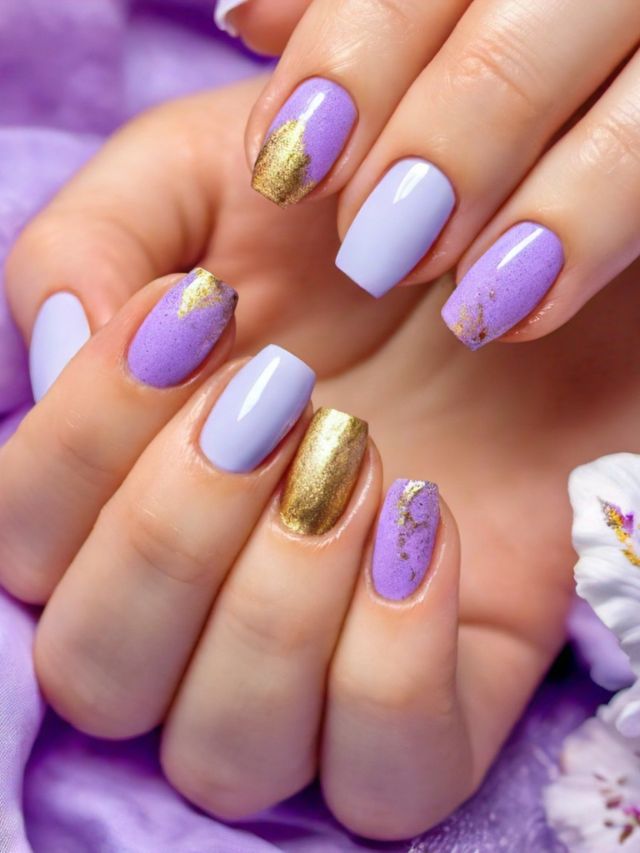 A woman's hands showcasing stunning purple and gold Easter-themed nail designs.