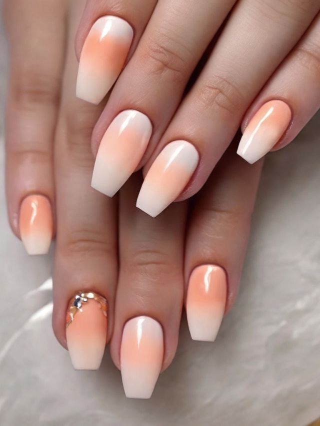 A woman's hands with peach and white ombre nails.