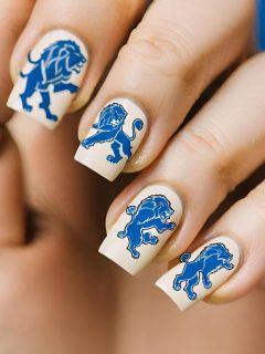 A woman's nails are decorated with blue and white lions.