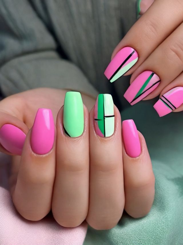 A woman's pink and green nails with geometric designs featuring both pink and green nail designs.