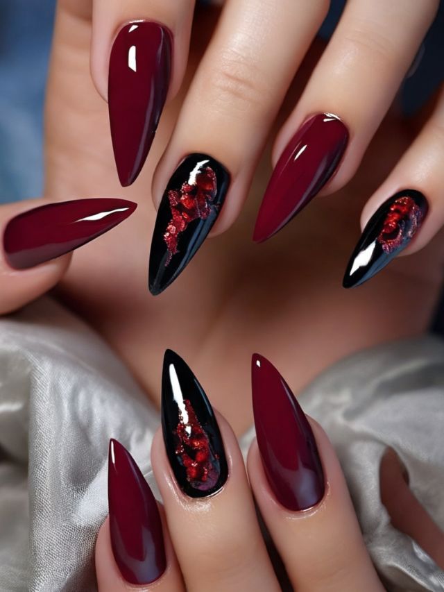A woman's hand adorned with burgundy nails and red flowers, showcasing a cute fall nail design.
