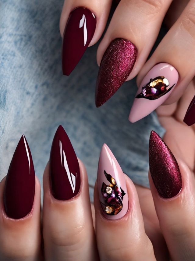 A woman's hands adorned with beautiful burgundy nails and delicate flowers.