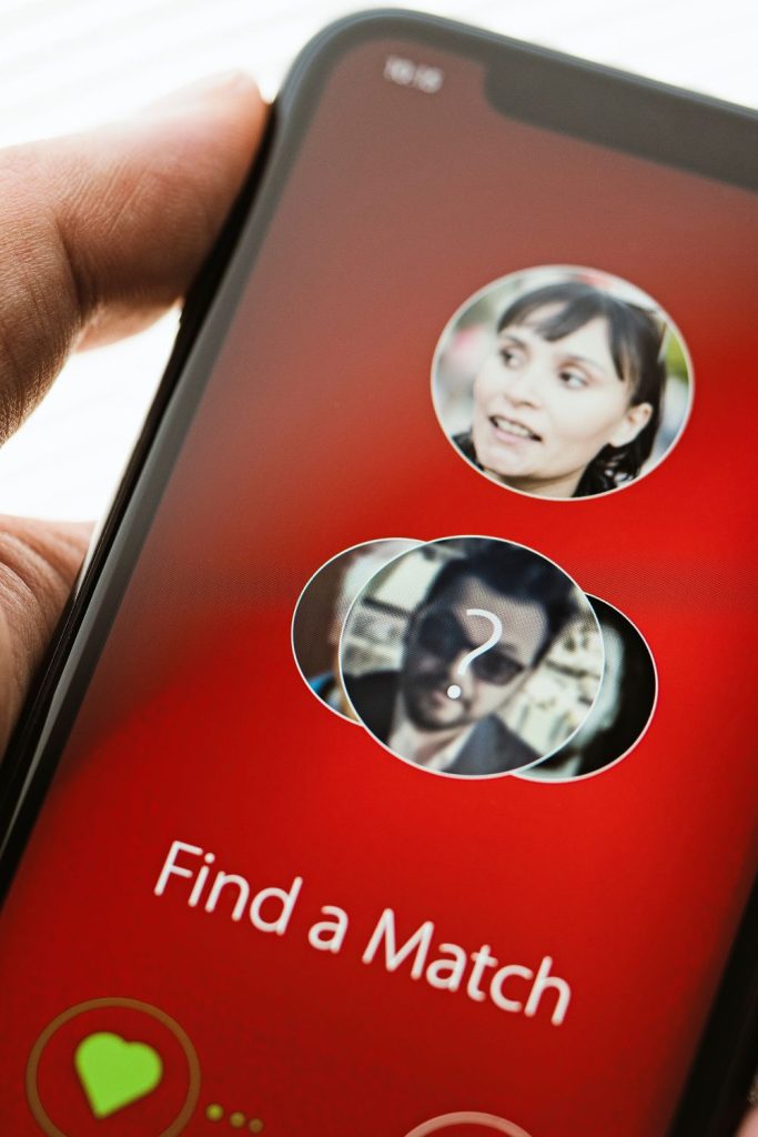 A person holding a cell phone with the word "find a match" on it, perfect for girls and guys creating their dating profile headlines.