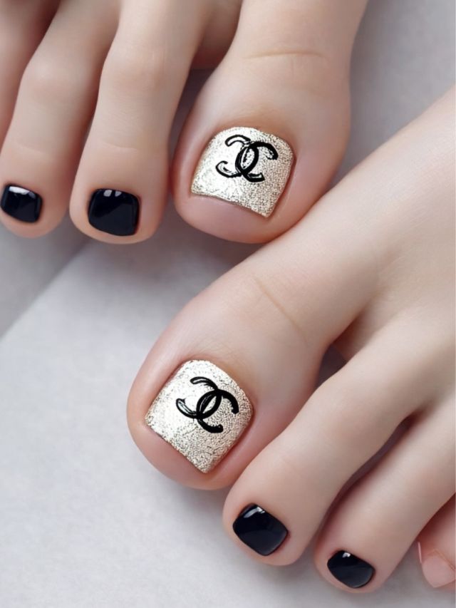 A woman's toe nails decorated with the Chanel logo, showcasing cute fall nail art designs.