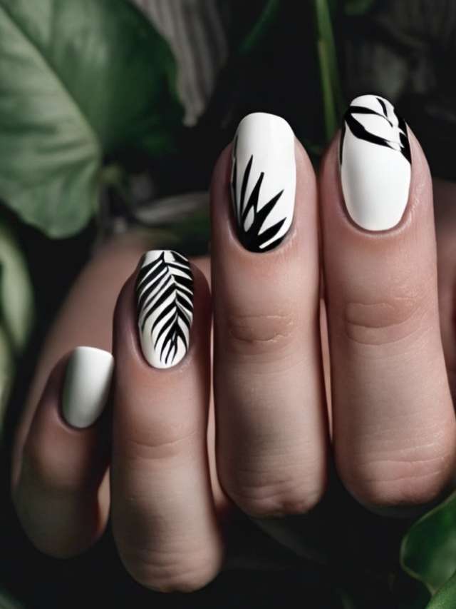 A woman's hand with black and white nail designs.