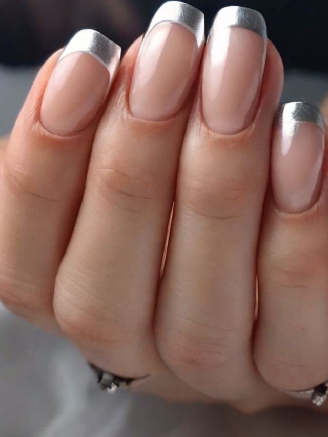 A woman's hands adorned with silver and beige nails, perfect for a silver wedding.