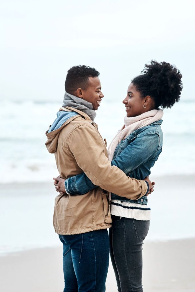 A couple embracing on a beach.