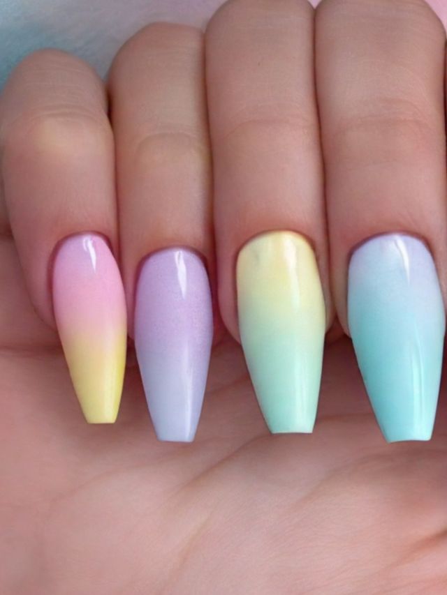 A woman's hand holding a pair of pastel colored nails, perfect for Easter.