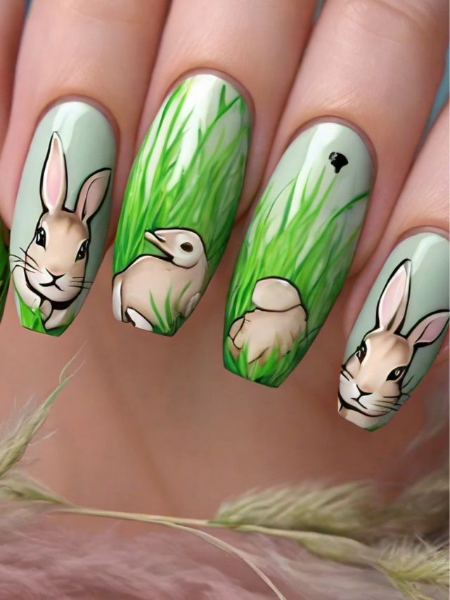 A woman's nails are beautifully decorated with easter bunny nail designs, featuring adorable bunnies and grass.