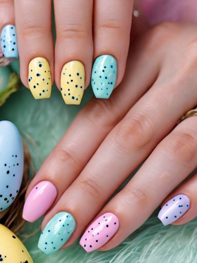 A woman's hands adorned with vibrant nail polish showcasing creative Easter egg designs.