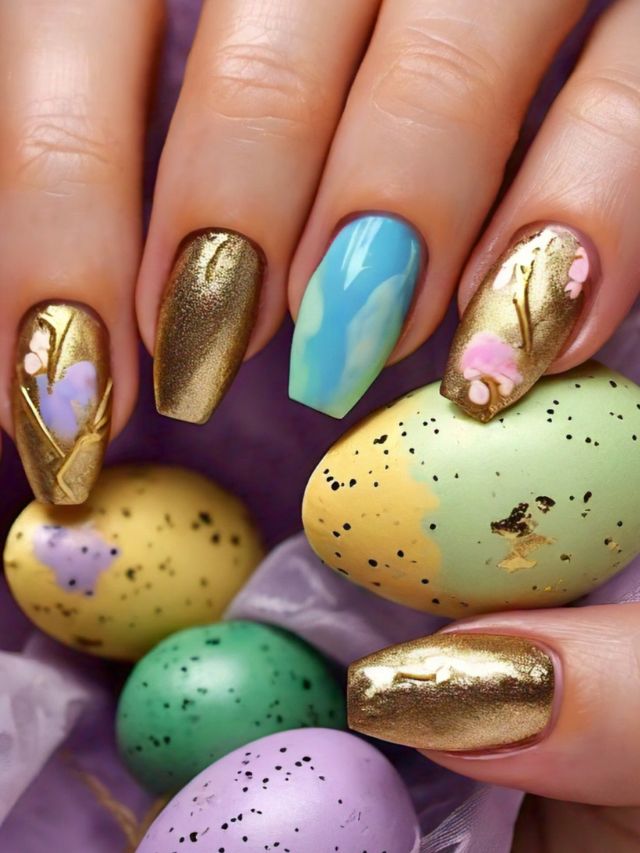 A cute woman's hand holding a gold and purple Easter egg with charming nail designs.