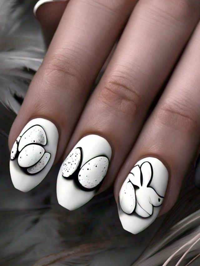 A woman's hands adorned with cute Easter Egg-inspired nail designs in both white and black, showcasing creative ideas.
