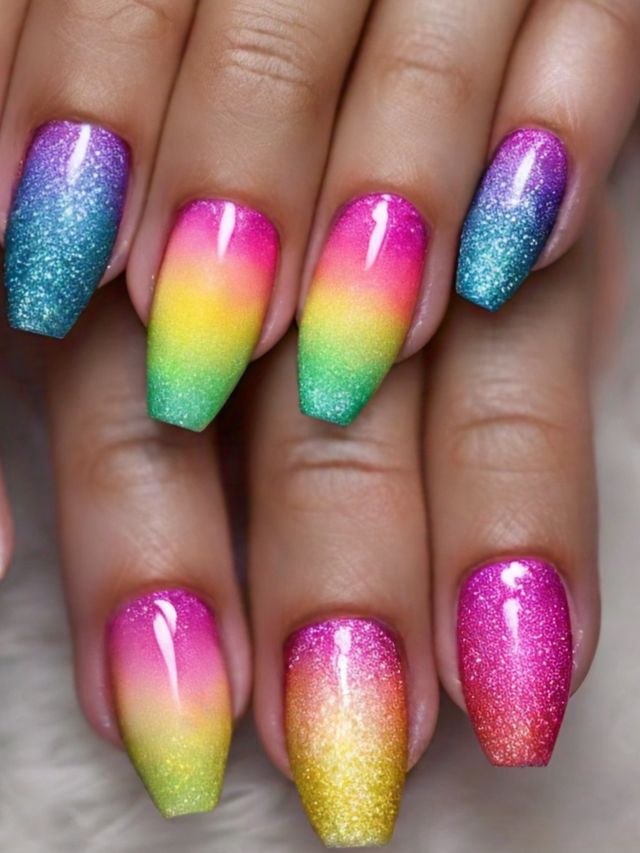 A woman's hand with rainbow colored nails in inspiring designs.