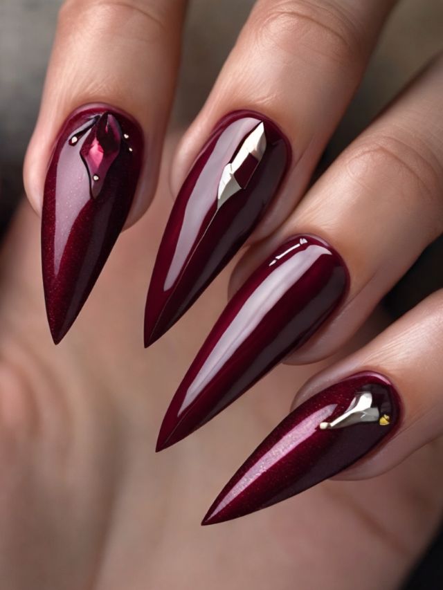 A woman's hand with stylish burgundy stiletto nails, perfect for a cute fall toe nail design.