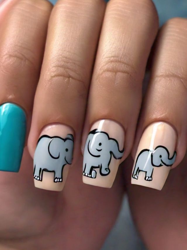 A woman is holding up a pair of nails with elephants on them.
