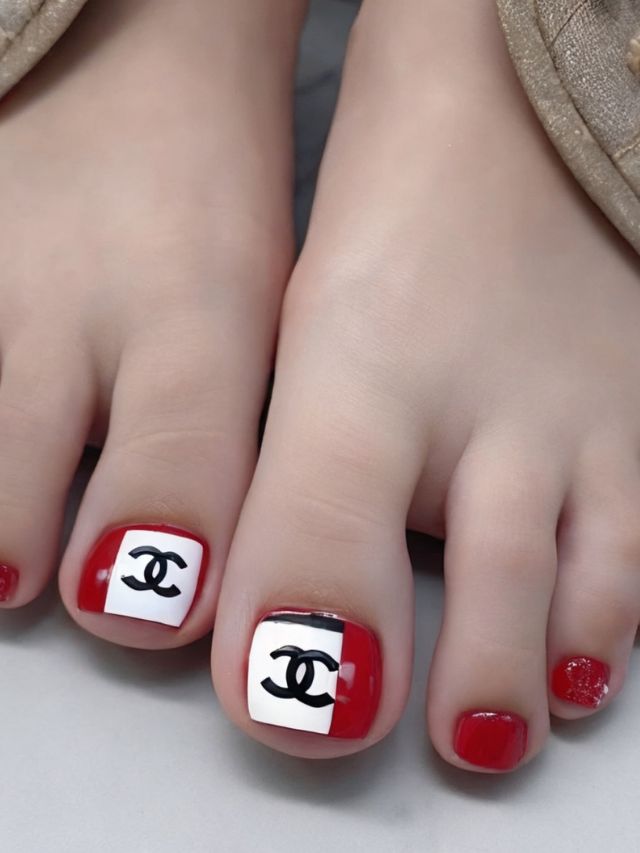 A woman's toes with chanel logos on them.