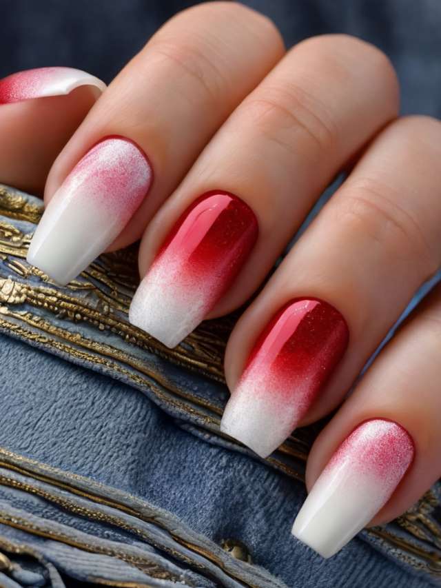 A woman's hand with red and white ombre nails.