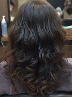 A woman's long wavy hair, beautifully permed to prevent damage.