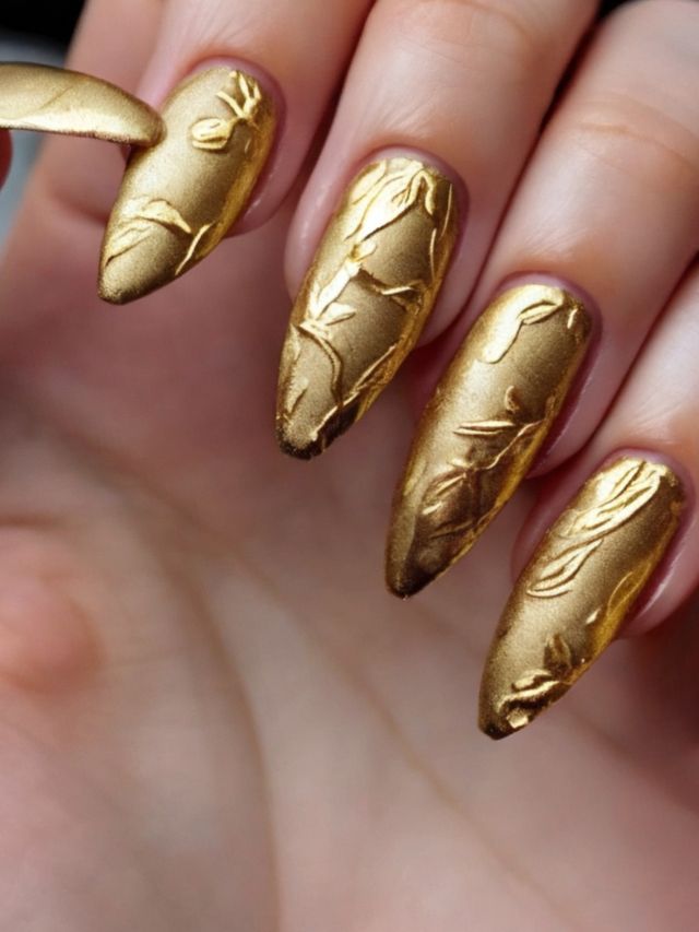 A woman showcasing a gold nail with an exquisite leaf design in January.