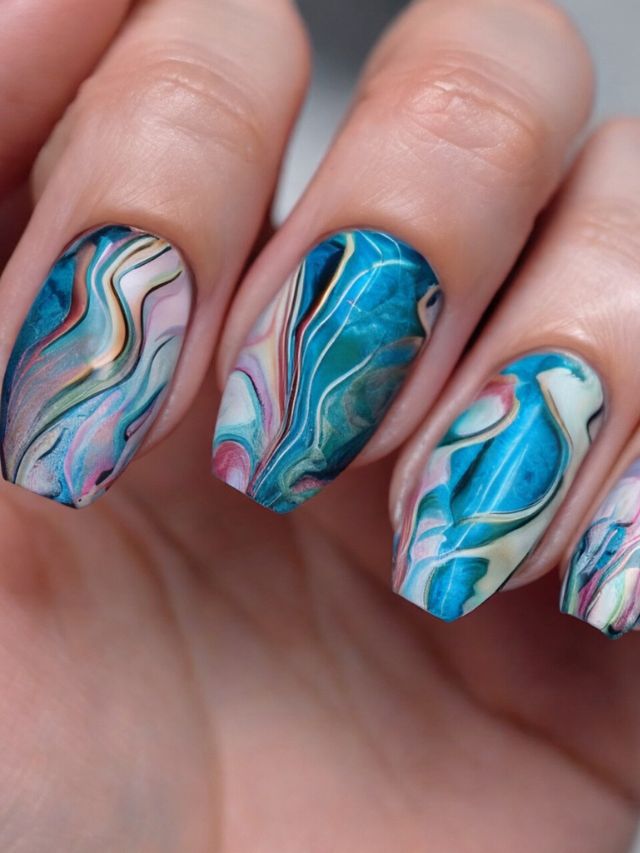 A woman's nails with mesmerizing marble designs.