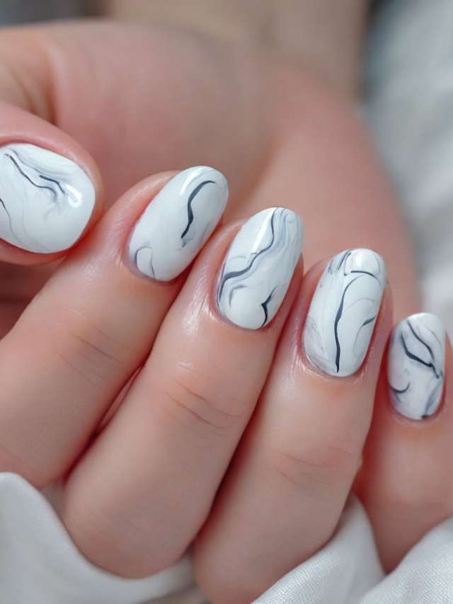 A woman's hand with white and black marble nails.