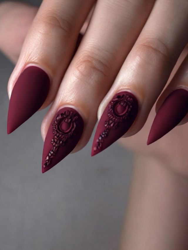 A woman's hand with burgundy nails showcasing a cute fall toe nail design.