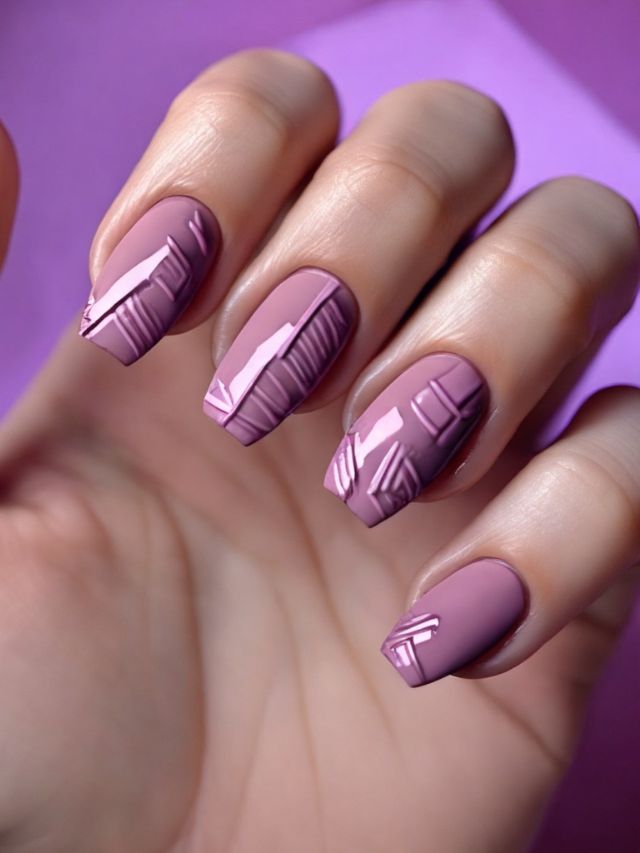 A woman is holding a purple nail with a geometric design on it.