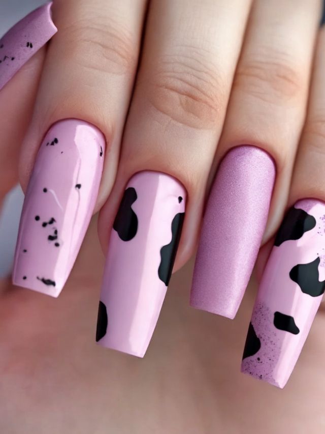 A pink nail with black and white polka dots on it.