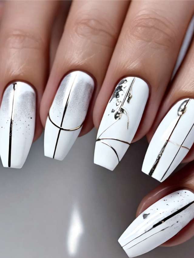 A woman's nails with white and gold designs.