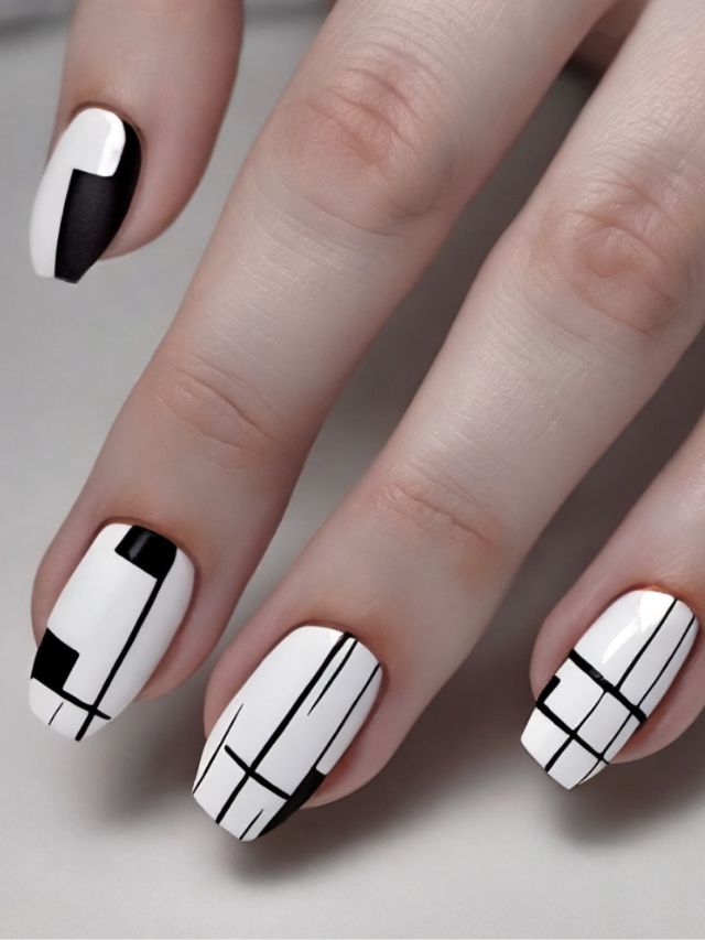 A woman's nails with black and white geometric designs, perfect for January.