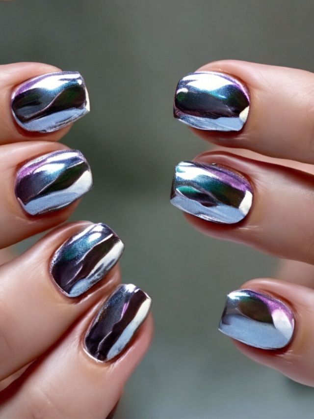 A woman is showcasing her stunning silver holographic design on her nails.