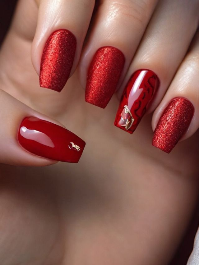A woman's hand with red nails and gold accents.