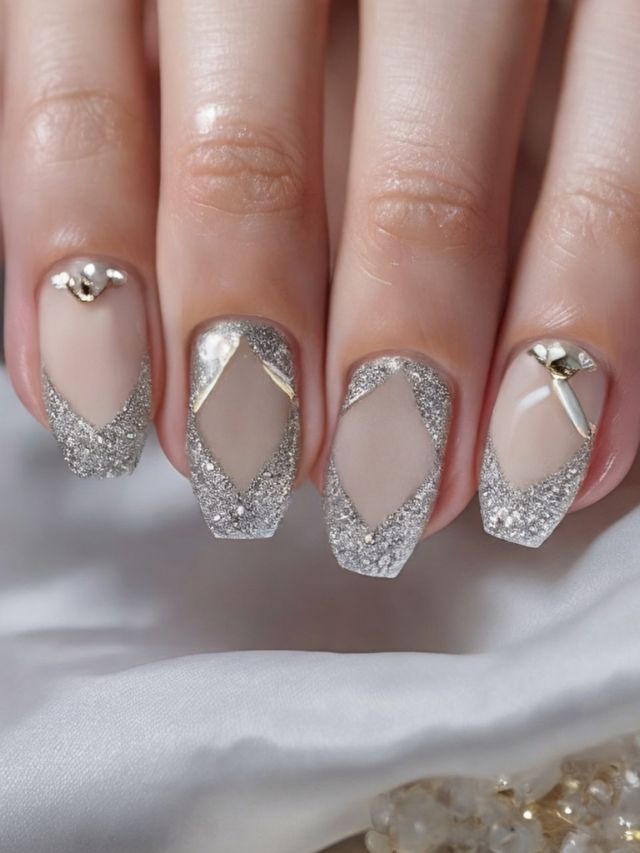 A woman's nails are decorated with silver and white glitter.
