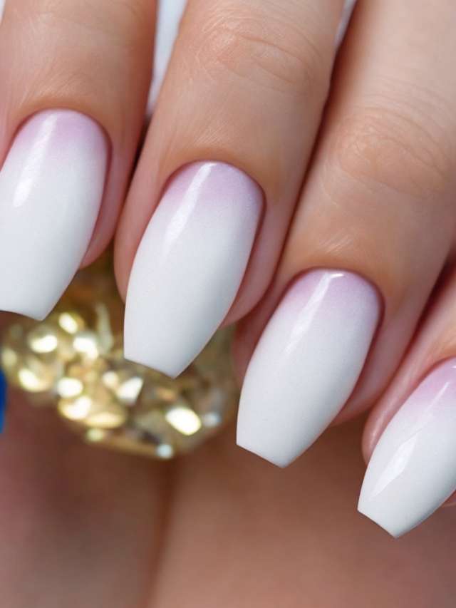 A woman's hand with white and pink ombre nails.
